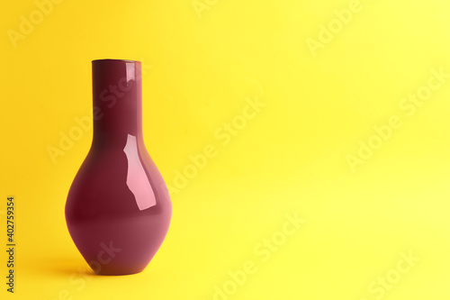 Stylish empty ceramic vase on yellow background, space for text