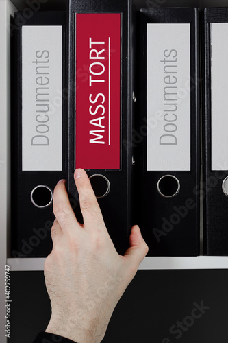 Mass Tort. Folder with label on the shelf of a lawyer. Red label with text in focus.
