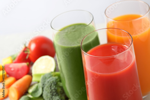 Different tasty juices in glasses on white background, closeup. Space for text