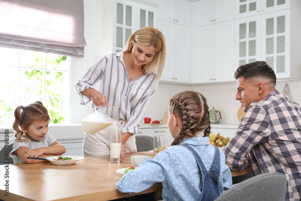 Happy family having breakfast together at table in modern kitchen Happy family having breakfast together at table in modern kitchen