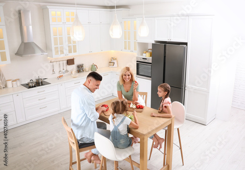 Happy family cooking together at table in modern kitchen