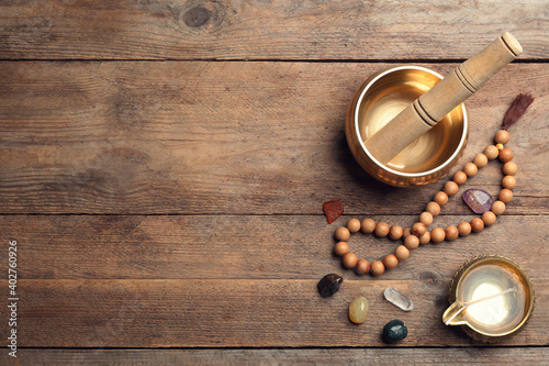 Photography Flat lay composition with golden singing bowl on wooden table, space for text