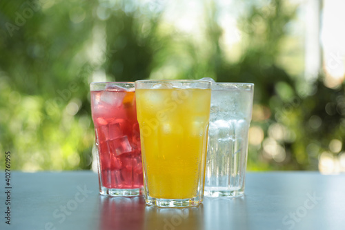 Delicious refreshing drinks in glasses on grey table outdoors