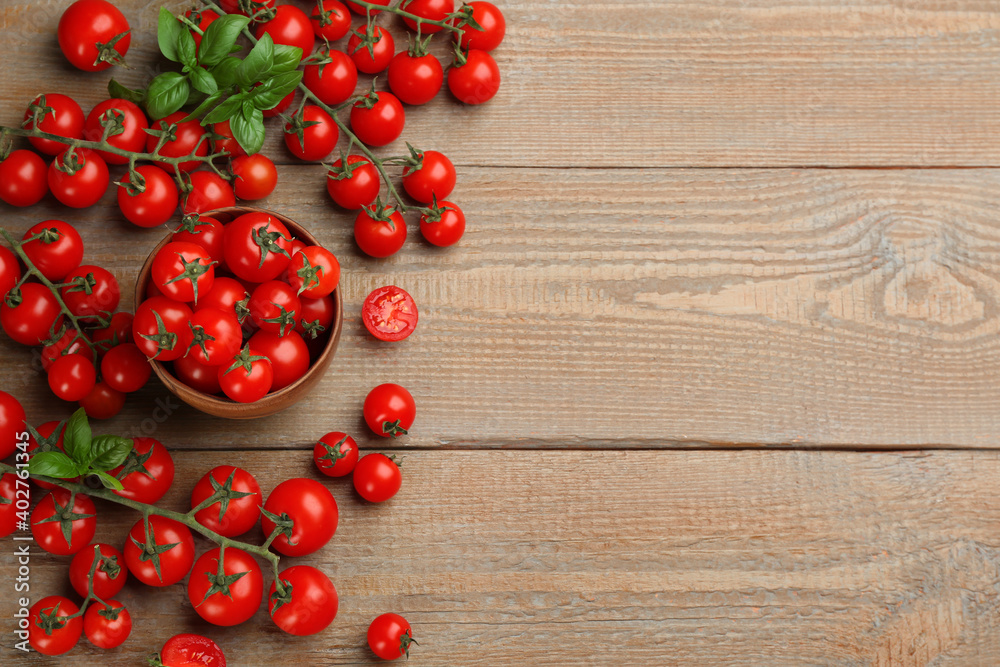 Fresh cherry tomatoes and basil leaves on wooden table, flat lay. Space for text Fresh cherry tomatoes and basil leaves on wooden table, flat lay. Space for text