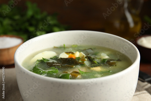 Delicious sorrel soup in white ceramic bowl, closeup