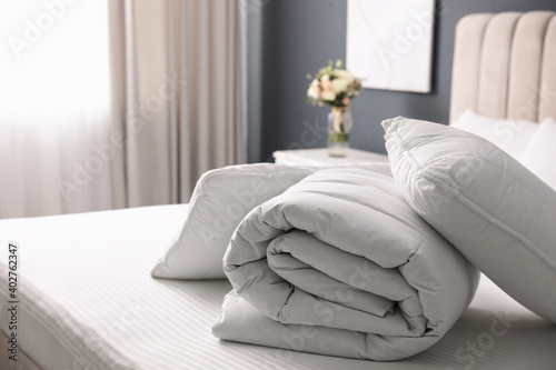 Soft folded blanket and pillows on bed indoors photo