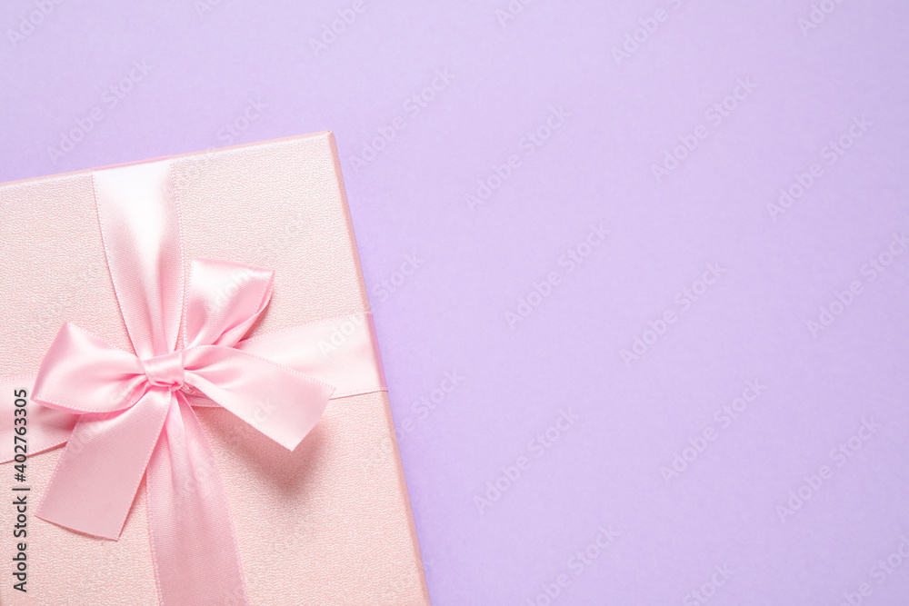 Pink gift box on violet background, top view. Space for text Pink gift box on violet background, top view. Space for text