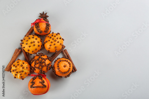 Christmas tree shape made of fresh tangerines and spices on light grey background, flat lay. Space for text