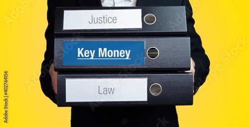 Key Money. Lawyer (man) carries a stack of folders. 3 file folders with text label. Background yellow. photo