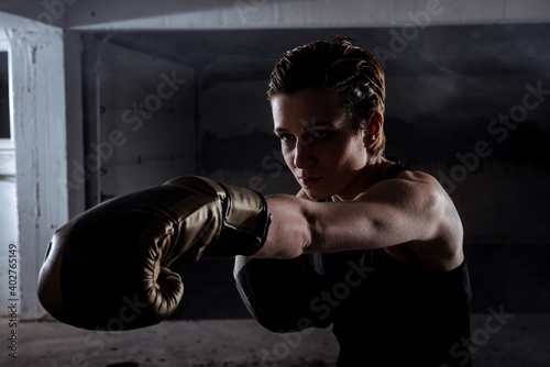 Side view of a silhouette female fighter punching with boxing gloves © qunica.com