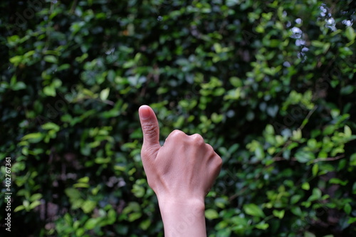A person's hand raises a thumb in agreement with something. The OK thumb symbol is also interpreted as an expression of positive appreciation for something that is happening in front of it