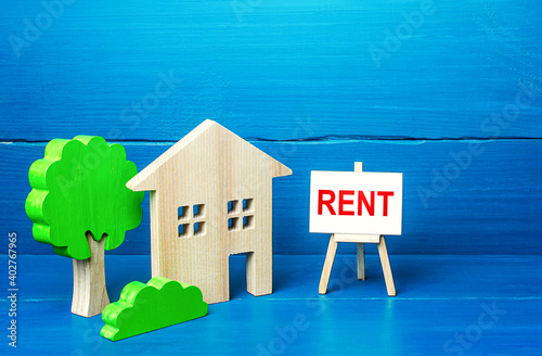 Residential building figurine and easel rent sign. Search for rental housing. Real estate realtor services. Legal procedure for concluding a contract. Protection rights of tenants and landlord owners. photo