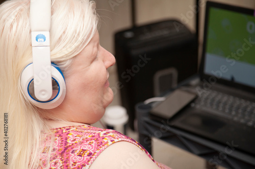 Visually impaired woman using a screen reader and headphones at a computer