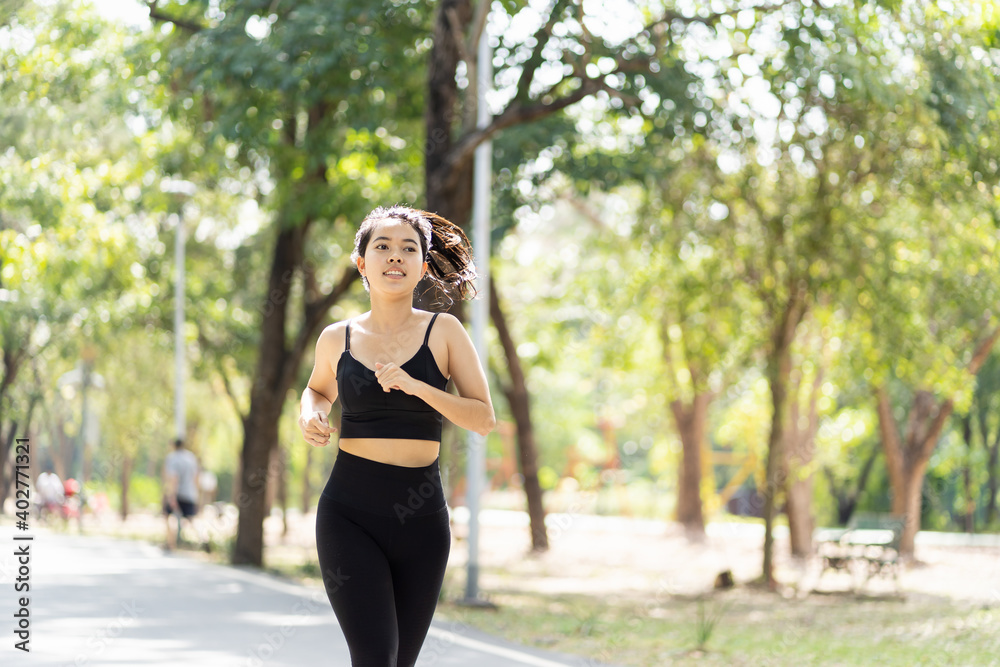Attractive Asian young woman runner running outdoor in the park. Sport girl in sportswear running or jogging in summer day. Woman, Sport and exercise concept Attractive Asian young woman runner running outdoor in the park. Sport girl in sportswear running or jogging in summer day. Woman, Sport and exercise concept
