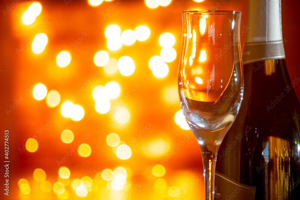 Empty champagne glass and bottle of sparkling wine or champagne with candlelit background in a romantic setting. Romanticism, toast, festivity concept. Empty champagne glass and bottle of sparkling wine or champagne with candlelit background in a romantic setting. Romanticism, toast, festivity concept.