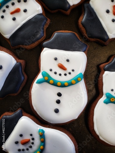 An adorable Christmas gingerbread cookie decorated to look like a happy snowman
