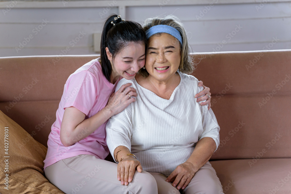 Asian young woman take care and support with hug, that make feel good and smile older mother in living room. family concept