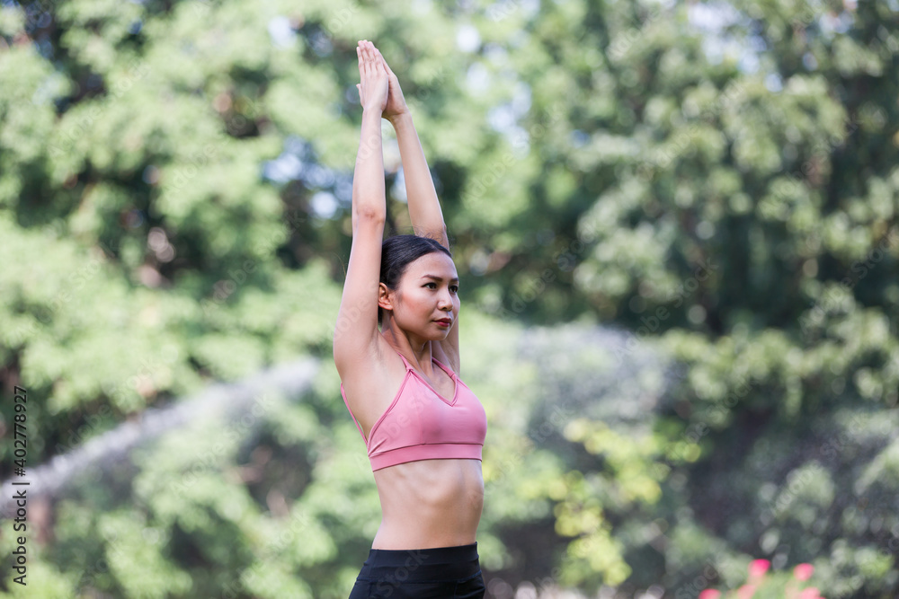 Portrait of half body Asian woman doing yoga with stretching arms outdoor in the park. Woman wearing sportswear and working out outdoor. Yoga and exercise outdoor concept Portrait of half body Asian woman doing yoga with stretching arms outdoor in the park. Woman wearing sportswear and working out outdoor. Yoga and exercise outdoor concept