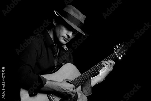 Black and white image of a man playing a guitar.
