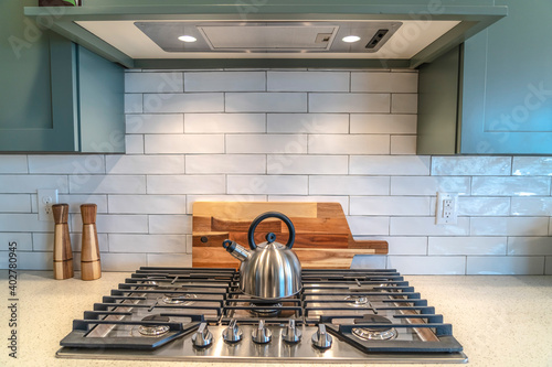 Kettle on top of a cooktop fixed on the countertop inside the kitchen of house