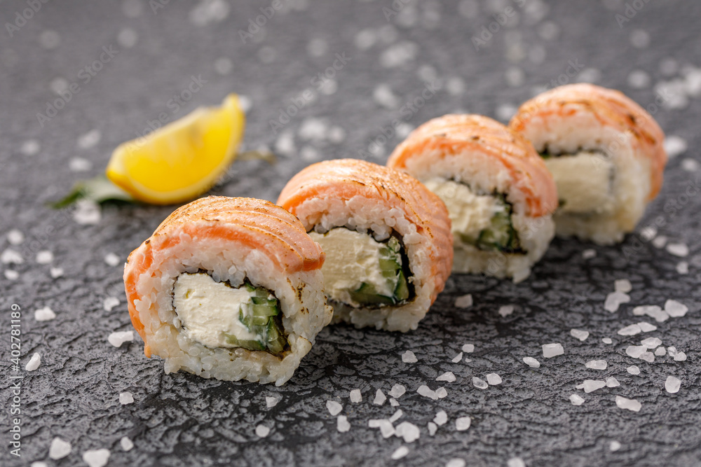 Sushi rolls Baked Philadelphia on textured still life background. Restaurant concept. Close-up. Sushi rolls Baked Philadelphia on textured still life background. Restaurant concept. Close-up.