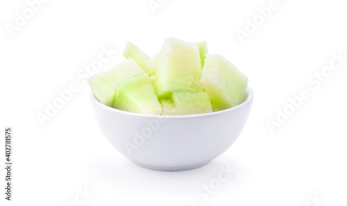 Green melon in white bowl on white background.