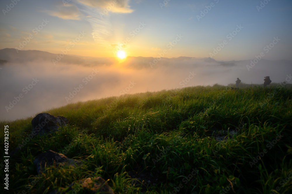 朝日　朝の雲海がたちこめる草原