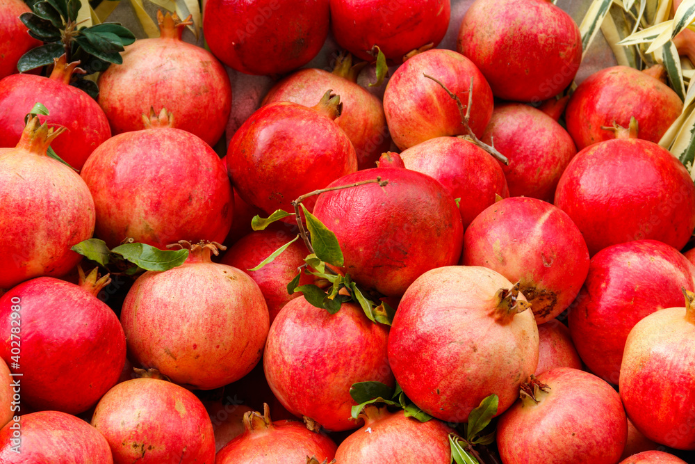 Heap of fresh pomegranates for sale in market. Background of pomegranate fruits Heap of fresh pomegranates for sale in market. Background of pomegranate fruits