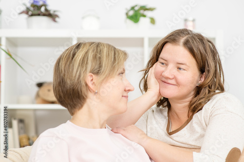 Caucasian gay couple talking, having conversation on sofa at home. Two women in love with each other, discuss problems in their relationships and solve problems