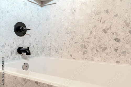 Minimalist bathroom interior with rectangular bathtub and white and gray wall