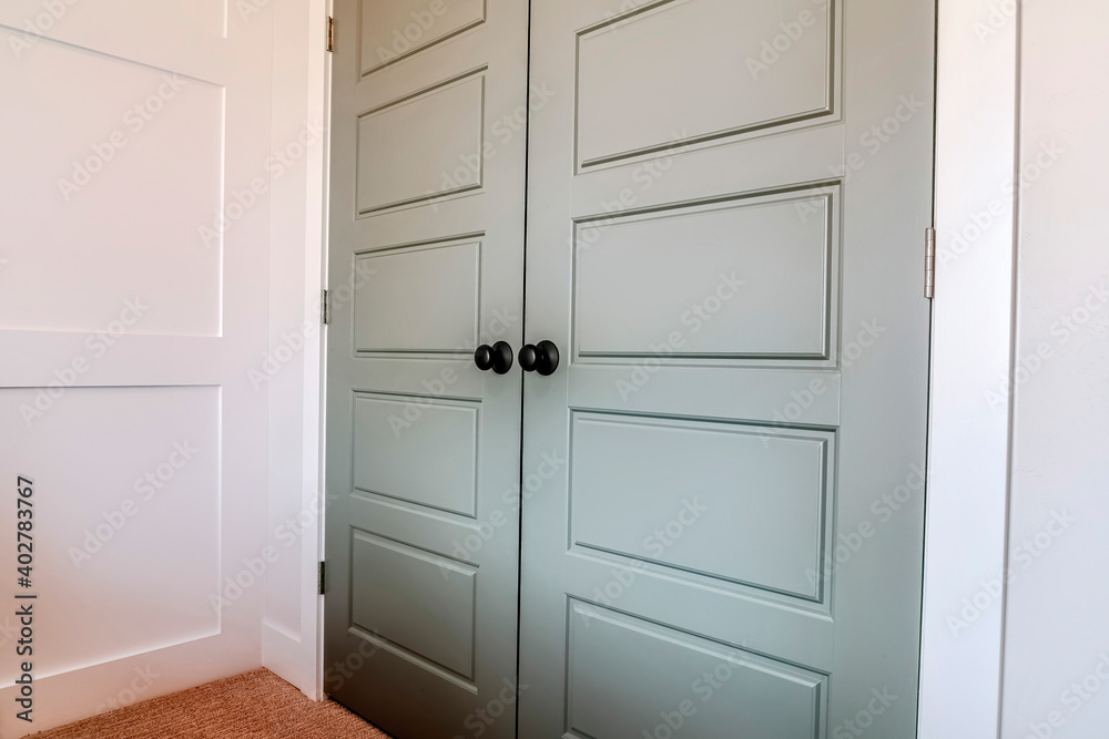 Double doors with hinges and black round doorknob at the bedroom entrance Double doors with hinges and black round doorknob at the bedroom entrance