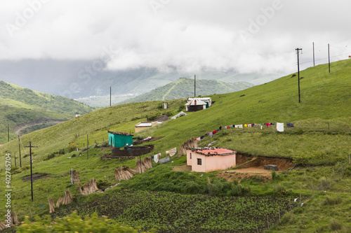 Rural landscape Transkei South Africa with green hills and houses on a cloudy day photo
