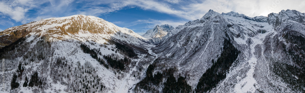 Aerial panorama from a drone of winter mountains and snow-capped hills. Location Dobay, Russia