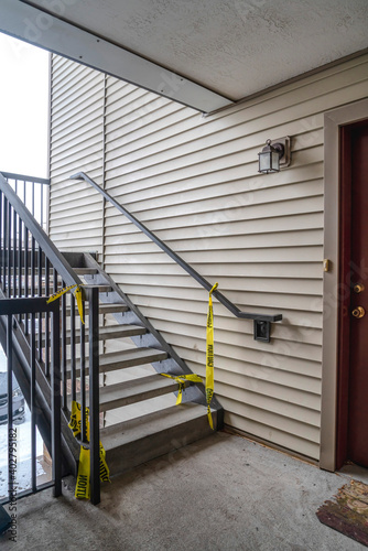 Exterior stairway of residential building with yellow caution construction tape