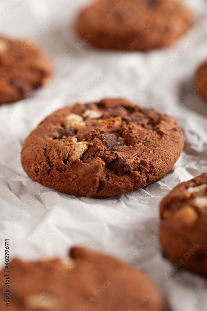 Fototapeta premium Chocolate cookies on white torn paper.