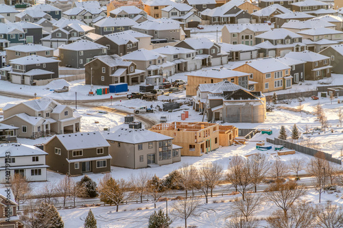 Neighborhood landscape in the sunlit snow covered valley terrain in winter