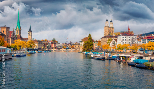 Сharm of the ancient cities of Europe. Dramatic afternoon view of Fraumunster and Grossmunster Churches. Colorful autumn cityscape of Zurich, Switzerland. Morning on Limmat River.