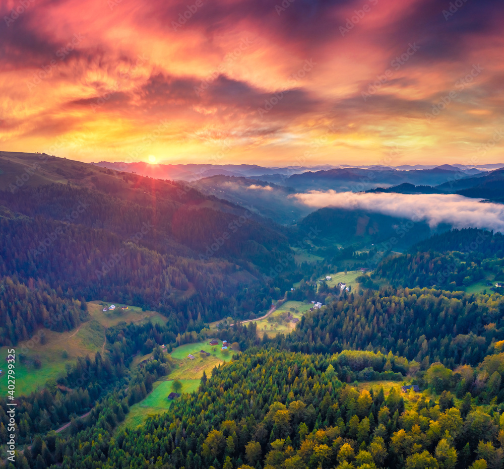 Beautiful summer scenery. Spectacular sunrise on Carpathian mountains. Fog spreads on the valley of Snidavka village, Ukraine, Europe. Majestic landscape of mountain hills glowing by sunlight.