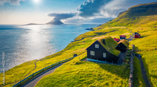 Beautiful summer scenery. Captivating summer view from flying drone of Velbastadur village with Koltur Island on background. Spectacular morning scene of Streymoy island, Faroe, Denmark. photo