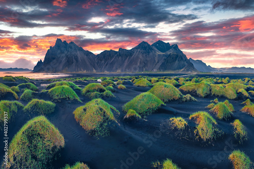 Aerial landscape photography. Fantastic view from flying drone of black sand dunes on Stokksnes cape with Vestrahorn (Batman Mountain) on background.Great sunrise in Iceland, Europe.