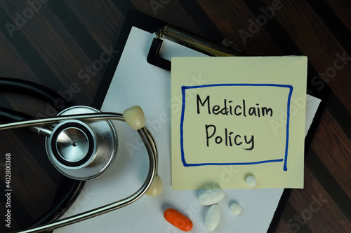 Mediclaim Policy write on sticky notes isolated on Wooden Table. Medical or Healthcare concept