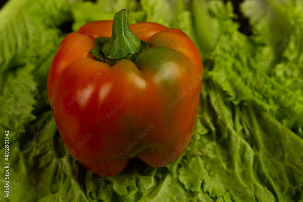 Fresh vegetables, red pepper lies on lettuce leaves on a dark wooden background. Fresh vegetables . Fresh vegetables, red pepper lies on lettuce leaves on a dark wooden background. Fresh vegetables .