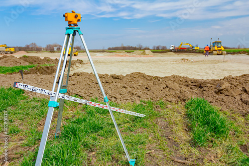 Obraz na płótnie Geodesist device with leveling rod on tripod on a building site
