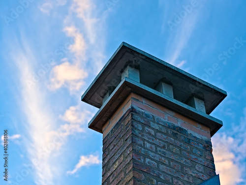 Ein Ziegelschornstein auf einem Hausdach, fotografiert gegen den Himmel