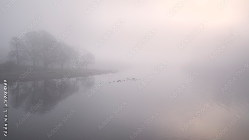 Fototapeta premium Stunning landscape image of misty Derwentwater in Lake District on cold Winter morning