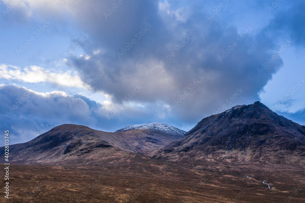 Flying drone epic landscape image of mountains rivers and valleys in Glencoe in Scottish Highlands on a Winter day