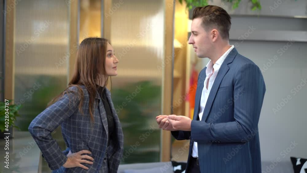 businessman and businesswoman standing and talking in office businessman and businesswoman standing and talking in office