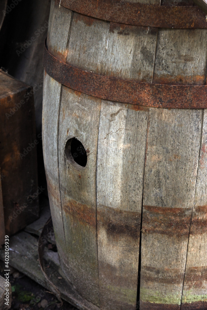 Old wooden barrel with hole and iron rims Old wooden barrel with hole and iron rims