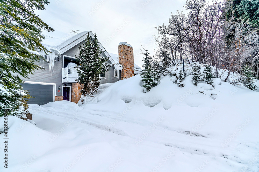 House facade and snowy hill slope against cloudy sky on a winter landscape House facade and snowy hill slope against cloudy sky on a winter landscape