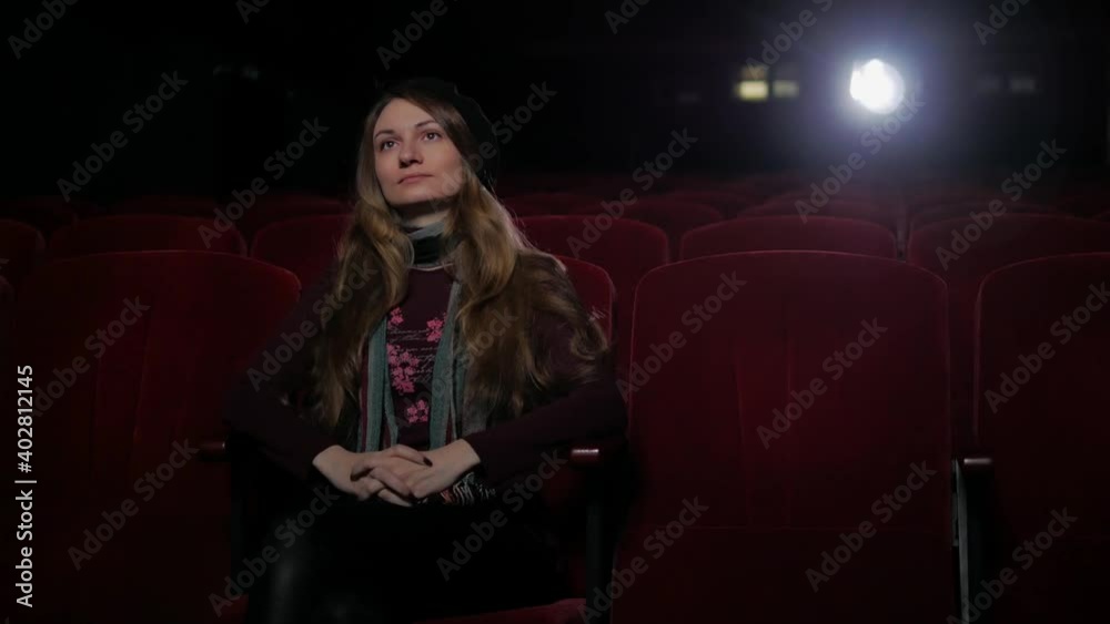 woman siting alone in cinema and watching film woman siting alone in cinema and watching film